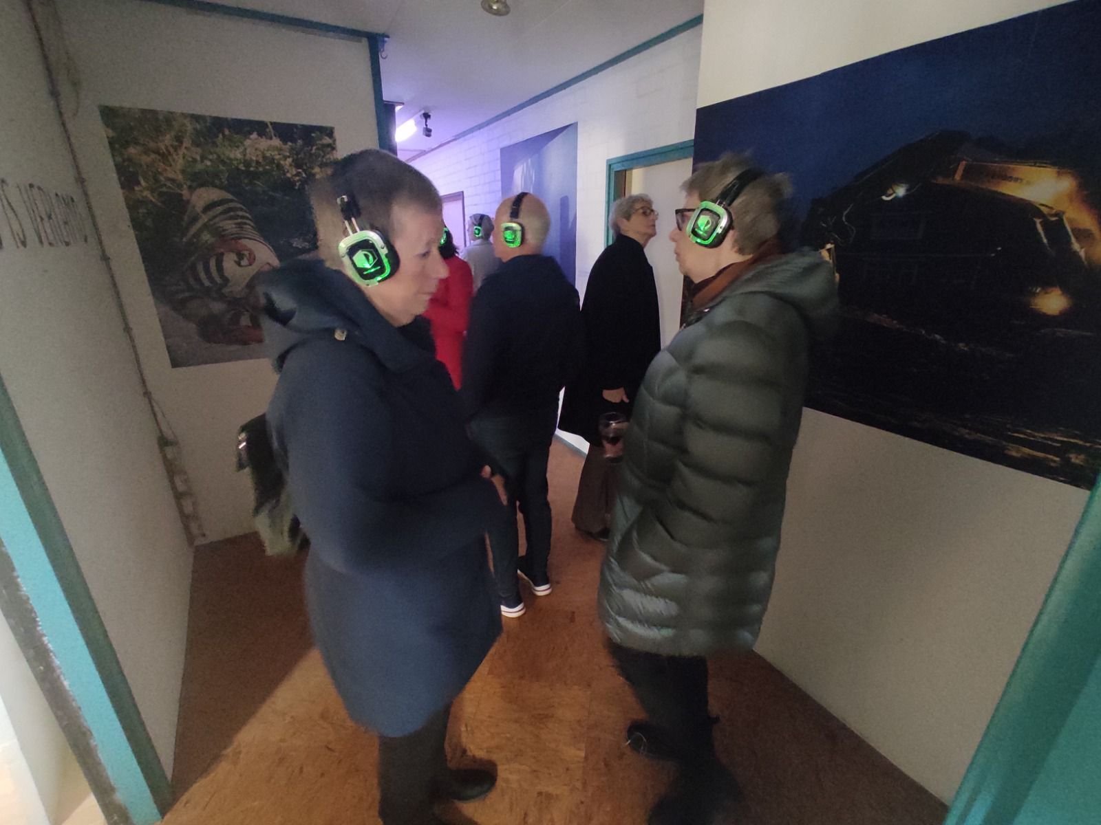 Visitors listening to residents’ stories inside the exhibition