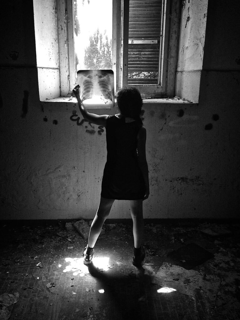 Silhouette beneath an open window in a textured room