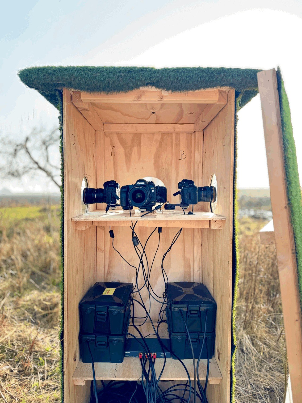 Inside the wooden camera rig: Canon cameras, protective cases and cables used to observe the garden