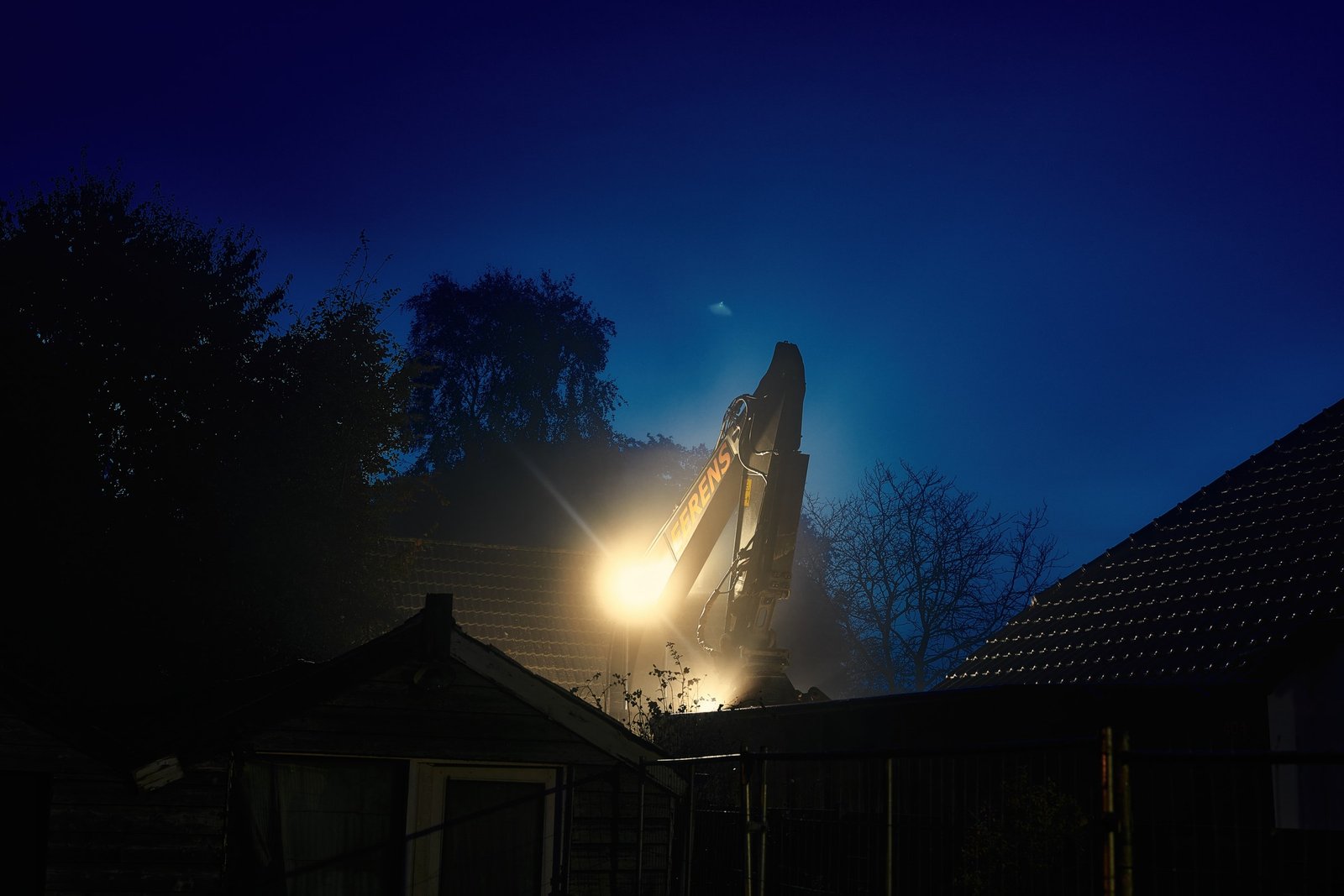 Demolition taking place beneath a night sky
